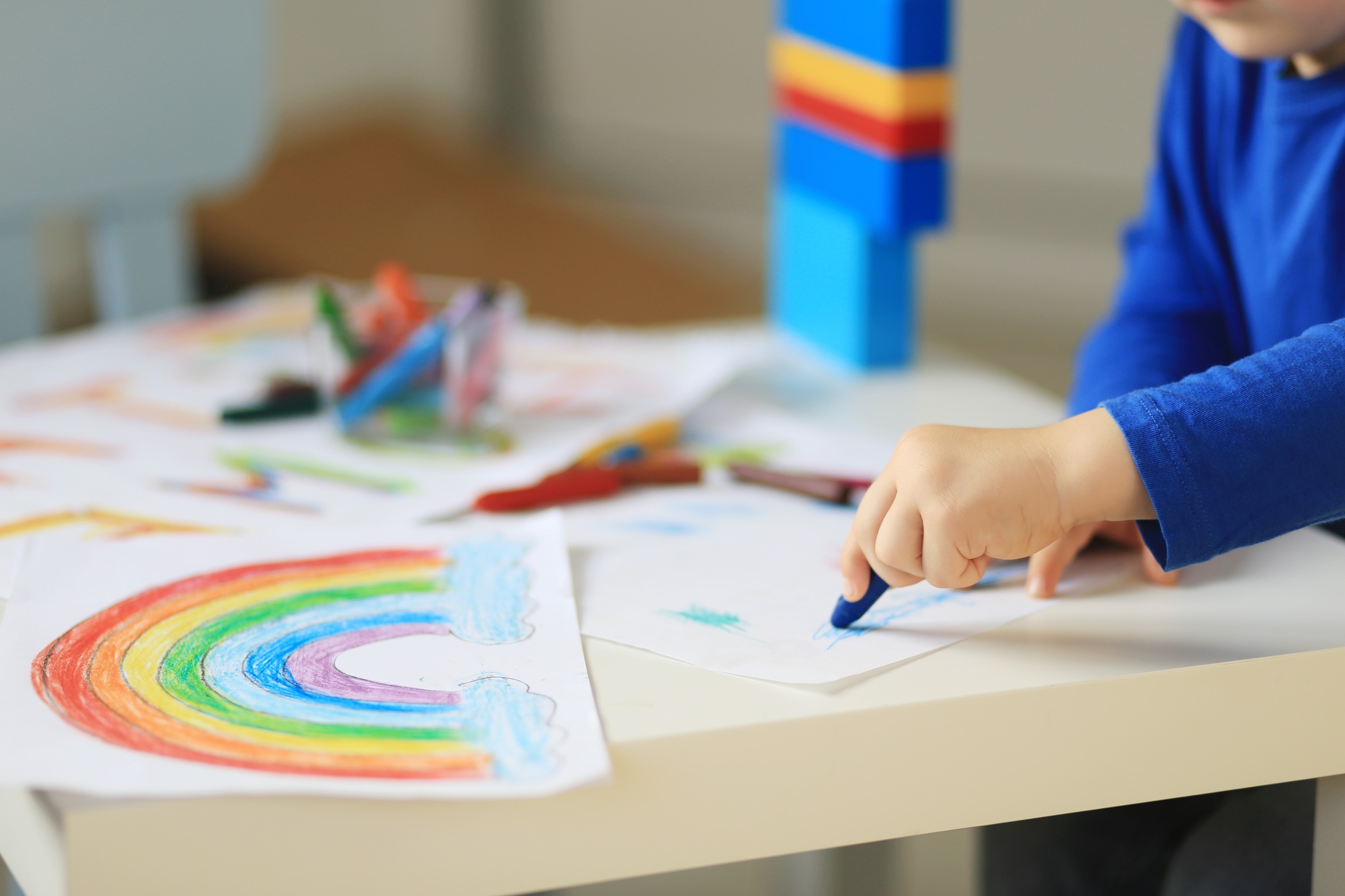 Child hand drawing rainbow