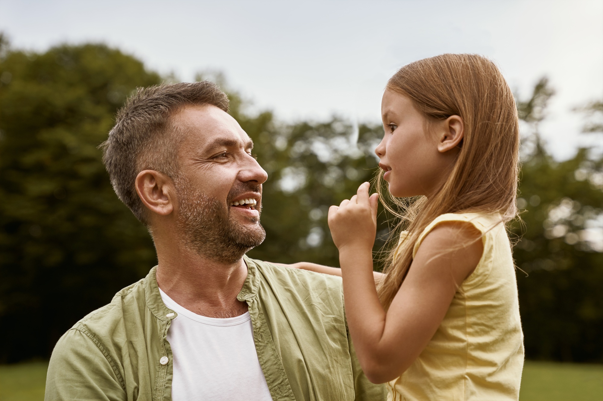 Daughter and daddy. Cute little girl spending time with father while visiting park on a summer day