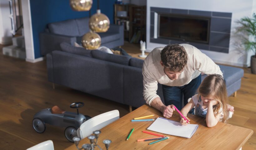 Father helping his daughter to make a drawing