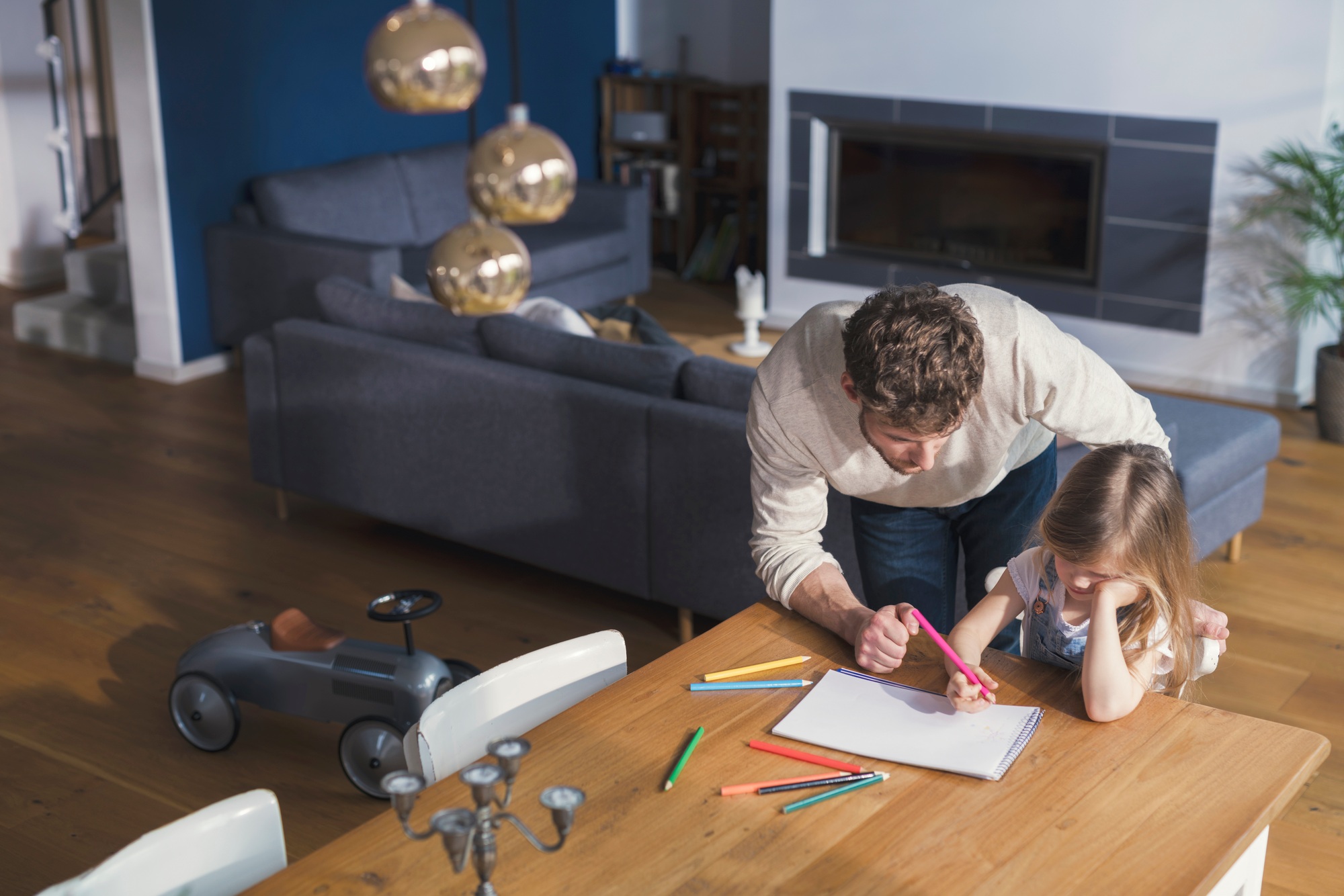 Father helping his daughter to make a drawing