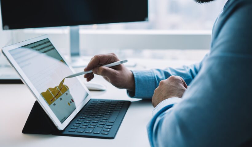 Unrecognizable male employee drawing chart on tablet with stylus