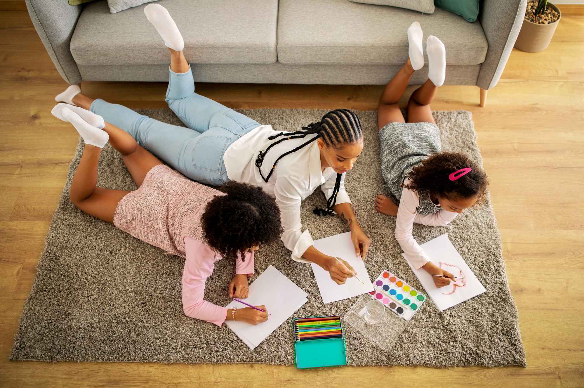 Above View Of African Family Drawing Lying On Floor Indoors