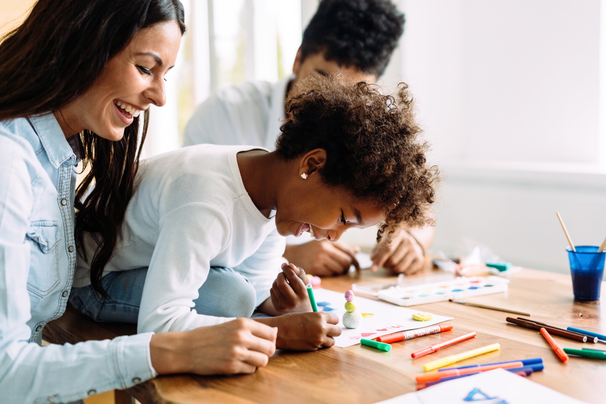 Mother and father drawing together with their child