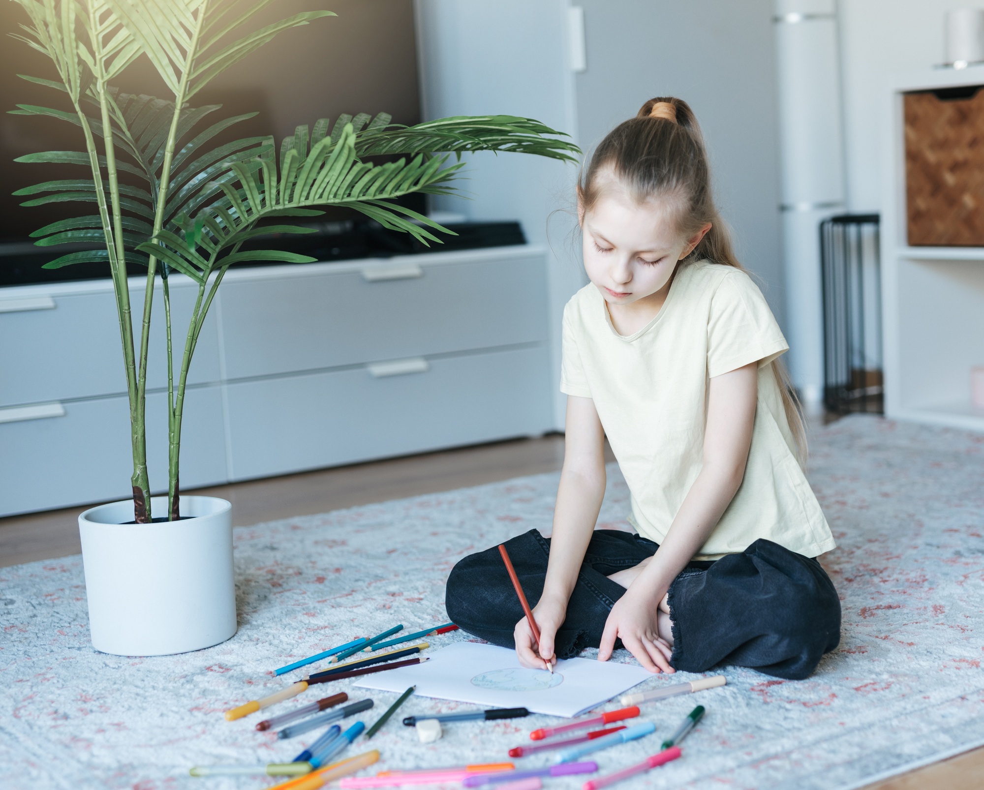 Child girl drawing with colorful pencils