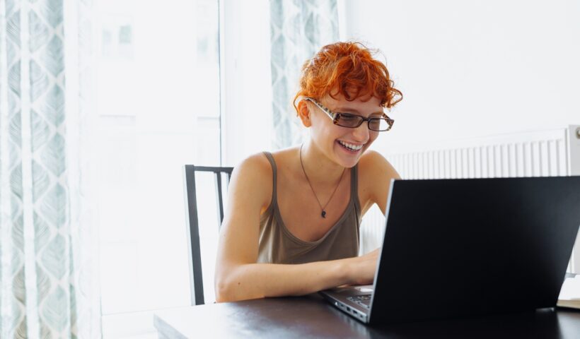 Tired teenager girl studying using computer at home