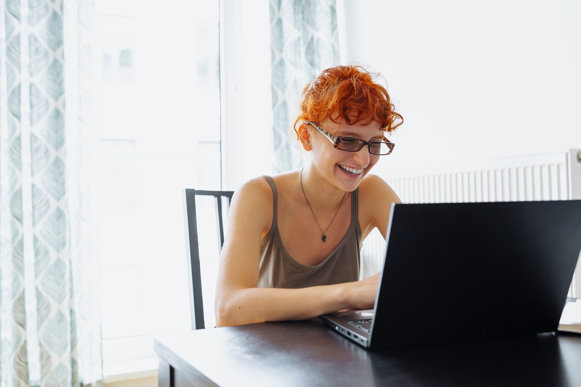 Tired teenager girl studying using computer at home
